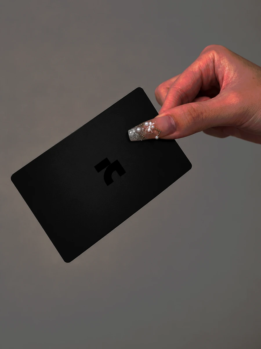 A hand holding the AnimaNext card over a cafe table, ready to tap